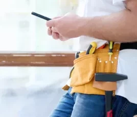 Artisan utilisant son smartphone pour un suivi de chantier.