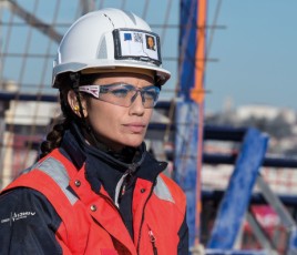 Femme portant des lunettes de protection Bollé Safety sur un chantier de BTP.