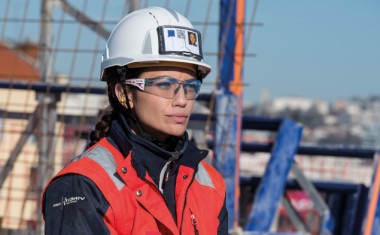 Femme portant des lunettes de protection Bollé Safety sur un chantier de BTP.