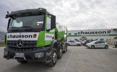 Camion de livraison devant une agence Chausson Matériaux.
