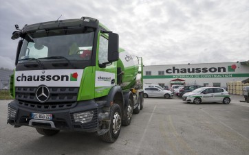 Camion de livraison devant une agence Chausson Matériaux.